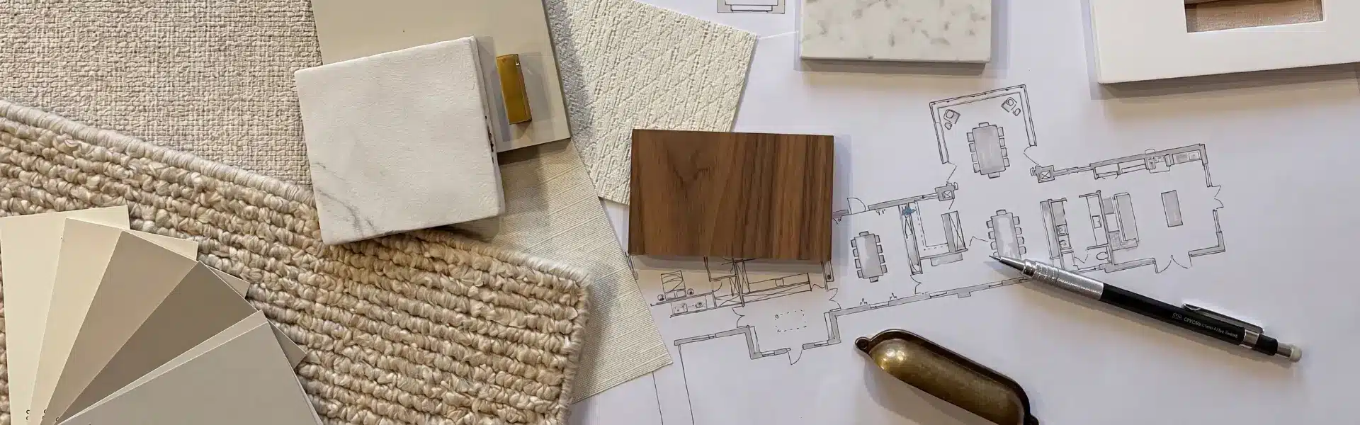 Architecte d'intérieur et décorateur : échantillons matières, marbre, bois, nuancier et plan d'aménagement sur une table.